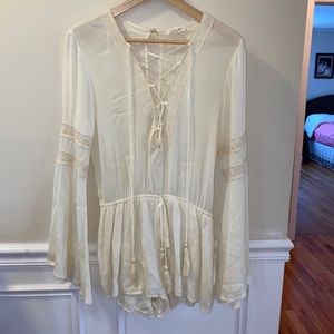 Off white flowy romper with lace detain and tie.
